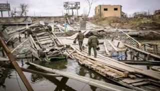 جنديان أوكرانيان يسيران على جسر مدمر في إيربين إحدى ضواحي كييف - أرشيفية