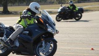 فتاة تقود دراجة نارية وتضع خوذة