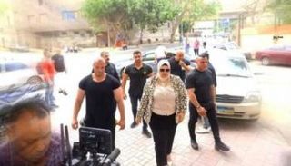 صورة للمعلمة أثناء تواجدها مع وسط حراسة مشددة 