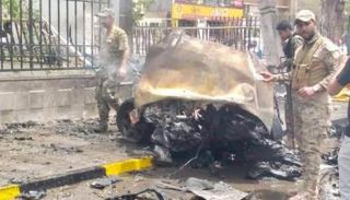 جنود أثناء إطفاء السيارة المفخخة بعد انفجارها بعدن