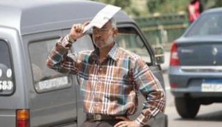 مواطن يحمي رأسه من أشعة الشمس الحارة