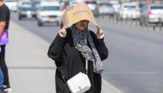 امراة تحتمي من أشعة الشمس