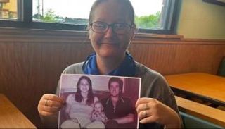 الأمريكية هولي تحمل صورتها مع والديها