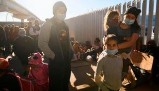 مهاجرون ينتظرون عند إحدى بواباب أمريكا الحدودية - بي بي سي