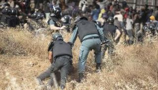 مهاجر يحاول تسلق السياج الحدودي لمدينة مليلية - أرشيفية