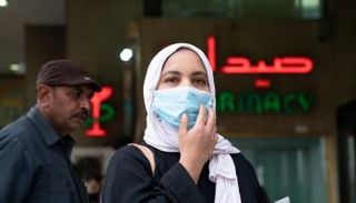 سيدة مصرية ترتدي الكمامة في الشارع