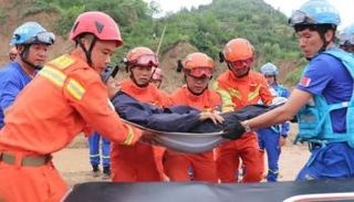 المسعفون ينقلون أحد الضحايا بموقع الحادث