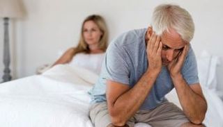 زوج وشريكته يجلسان على السرير- تعبيرية