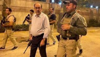 المالكي مسلحاً برفقة حماية شخصية عند المنطقة الخضراء