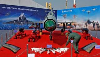 جندي هندي يرتب ذخائر أمام مقاتلة من طراز ميج-21 - رويترز