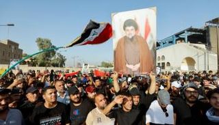أنصار الزعيم الشيعي مقتدى الصور يرفعون صورته خلال احتجاجات