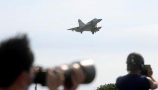 شخصان يلتقطان صورا لمقاتلة تايوانية لدى إقلاعها - رويترز