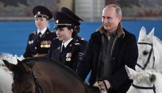 بوتين يمتطي حصانا برفقة ضابطات شرطة روسيات