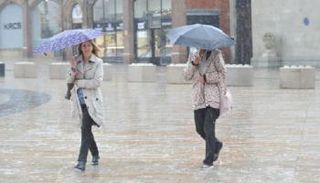 سيدتان تحتميان بالمظلة من مياه المطر - أرشيفية