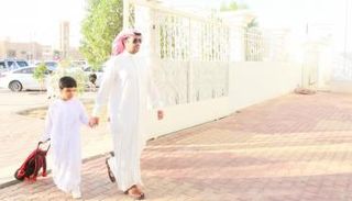 أب يصطحب نجله إلى المدرسة في أول أيام الدراسة