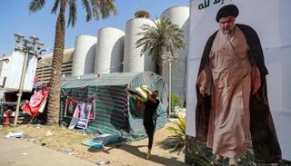 أحد أنصار الصدر ينقل أشياء أثناء تفكيك الاعتصام بالمنطقة الخضراء