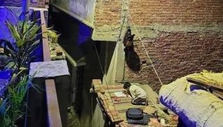 الطفل فوق سطح منزله يدرس على نور مصباح الشارع