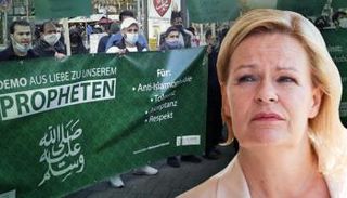 نانسي فيسر وخلفها مظاهرة لأنصار الإسلام السياسي