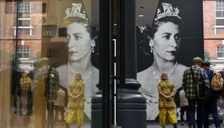 صورة لملكة بريطانيا إليزابيث معلقة في سوق سبيتالفيلدز في شرق لندن