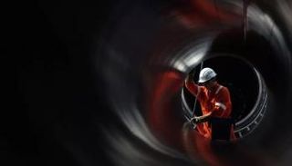 عامل يصلح أحد خطوط الأنابيب