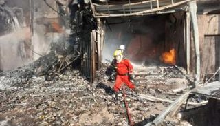 عناصر أطفاء خلال محاولتهم إخماد نيران حادثة حريق ببغداد