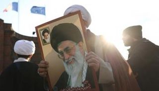 رجل دين إيراني يحمل صورة خامنئي في طهران- رويترز