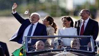 رئيس البرازيل لولا دا سيلفا وزوجته جانجا يلوحان لأنصارهما من موكب السيارات
