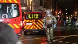 عنصر من الشرطة يرتدي زيا واقيا من الهجمات البيولوجية وقت المداهمة