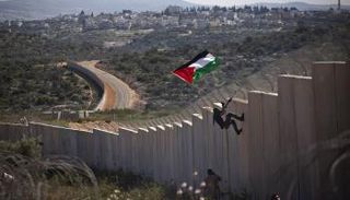 فلسطيني يتسلق الجدار الفاصل بالضفة الغربية
