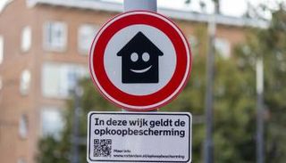 لافتة تظهر وجه متعجرف على شكل منزل يحدق في السكان في روتردام