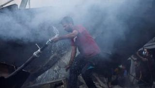 فلسطيني بين أنقاض منزل مدمر في غزة