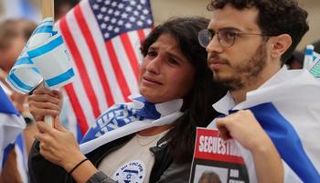 متظاهرون يحملون لافتات عليها صور الرهائن وأعلام إسرائيل وأمريكا