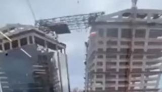 العمال يتدلون من الرافعة