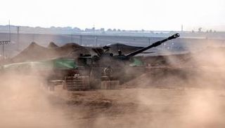 طاقم مدفعية إسرائيلي يستعد لإطلاق النار من حقل قرب مدينة سديروت باتجاه قطاع غزة