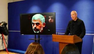 وزير الدفاع الاسرائيلي يوآف غالانت مع صورة السنوار 