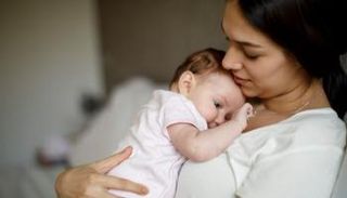 أم تحمل طفلها الرضيع