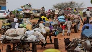 أصحاب عربات ينقلون متعلقات الذين فروا من الصراع في منطقة دارفور بالسودان