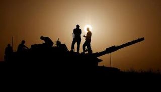 جنود إسرائيليون على متن دبابة قرب حدود غزة - رويترز