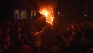 بعض سكان البلدة يحملون برميلًا مشتعلًا