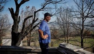 يوناني يعاين آثار حرائق اجتاحت بلاده جراء ارتفاع درجات الحرارة - رويترز