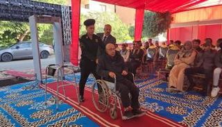 أحد كبار السن يدلي بصوته على كرسي متحرك