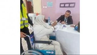 أحد كبار السن يدلي بصوته على كرسي متحرك