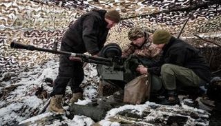 جنود أوكرانيون يفحصون دبابة القتال الرئيسية T-64 قرب خط المواجهة في دونيتسك 