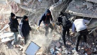 شباب يبحثون عن ناجين تحت أنقاض بناء في سوريا