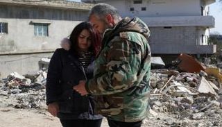 أم كنعان السورية مع زوجها بعد نجاتها وأطفالها من الزلزال- رويترز