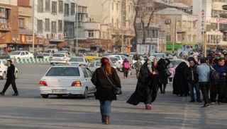 سيدة تمشي حاسرة الرأس في شوارع طهران تحديا لقانون الحجاب الإلزامي