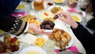 سيدة تقدم تمرا على مائدة الإفطار