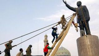 جنود أمريكيون وعراقيون يصعدون لتمثال صدام