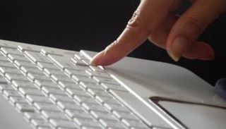 امرأة تضغط زرا على لوحة المفاتيح