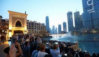 سائحون يتجمعون لمشاهدة نافورة موسيقية أمام برج خليفة  في دبي